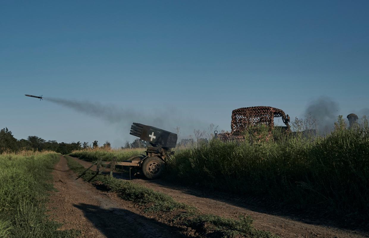 Ukrainian soldiers of the 28th brigade fire a mini-multiple launch rocket system towards the Russian position (AP)