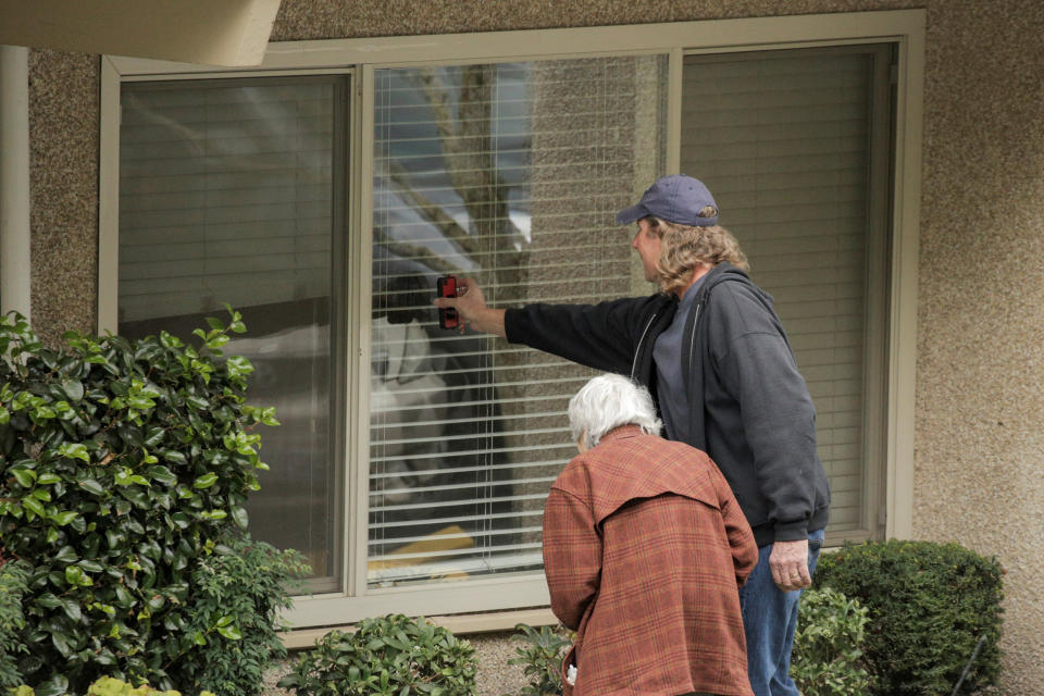 Image: Dorothy Campbell and her son, Charlie Campbell, talk through a window with her husband, Gene Campbell, at the Life Care Center of Kirkland, the long-term care facility linked to several confirmed coronavirus cases in the state, in Kirkland (David Ryder / Reuters)