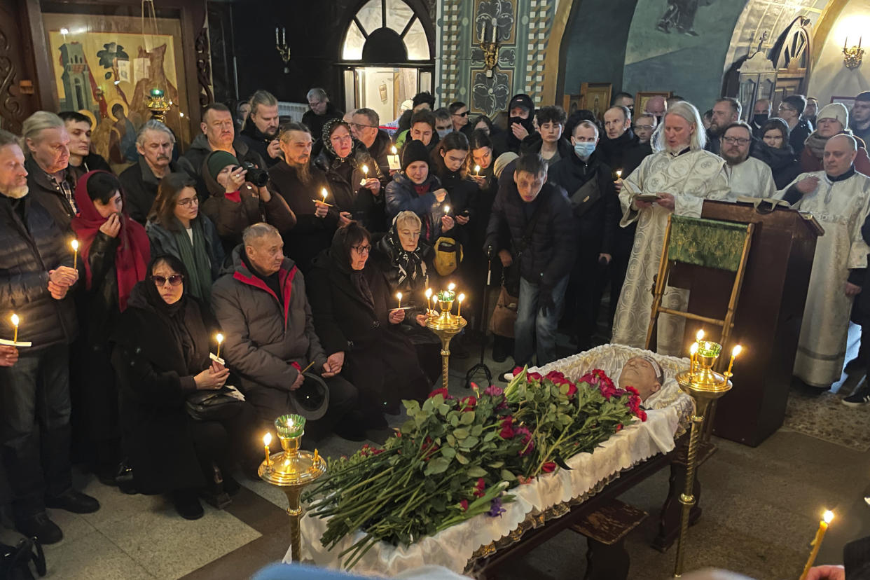 Relatives and friends pay their last respects to Navalny in front of his open casket. Navalny’s body is covered with long-stemmed roses.