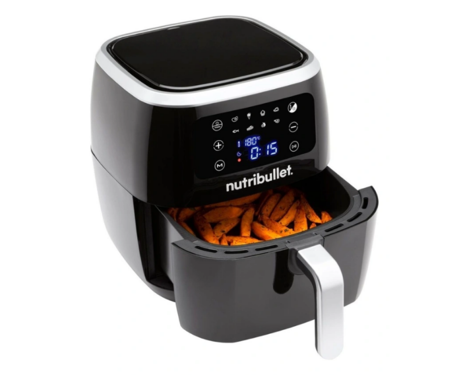 The black Nutribullet Air Fryer sits on a white background on an angle with the tray half opened to show baked sweet potato fries.