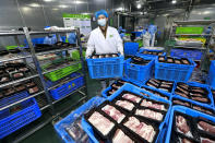In this Jan. 30, 2020, photo, workers prepare pork packages at a food processing plant in Suining city in southwest China's Sichuan province. China's communist leaders are striving to keep food flowing to crowded cities despite anti-disease controls, to quell fears of possible shortages and stave off price spikes from panic buying after most access to Wuhan was cut off Jan. 23. Food stocks in supermarkets ran low shortly after Beijing imposed travel curbs and extended the Lunar New Year holiday to keep factories, offices and other businesses closed and the public at home, attempting to prevent the virus from spreading. (Chinatopix via AP)