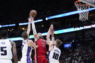 New Orleans Pelicans center Jonas Valanciunas (17) shoots between Sacramento Kings forward Sasha Vezenkov (7) and forward Domantas Sabonis (10) in the second half of an NBA basketball play-in tournament game in New Orleans, Friday, April 19, 2024. The Pelicans won 105-98. (AP Photo/Gerald Herbert)