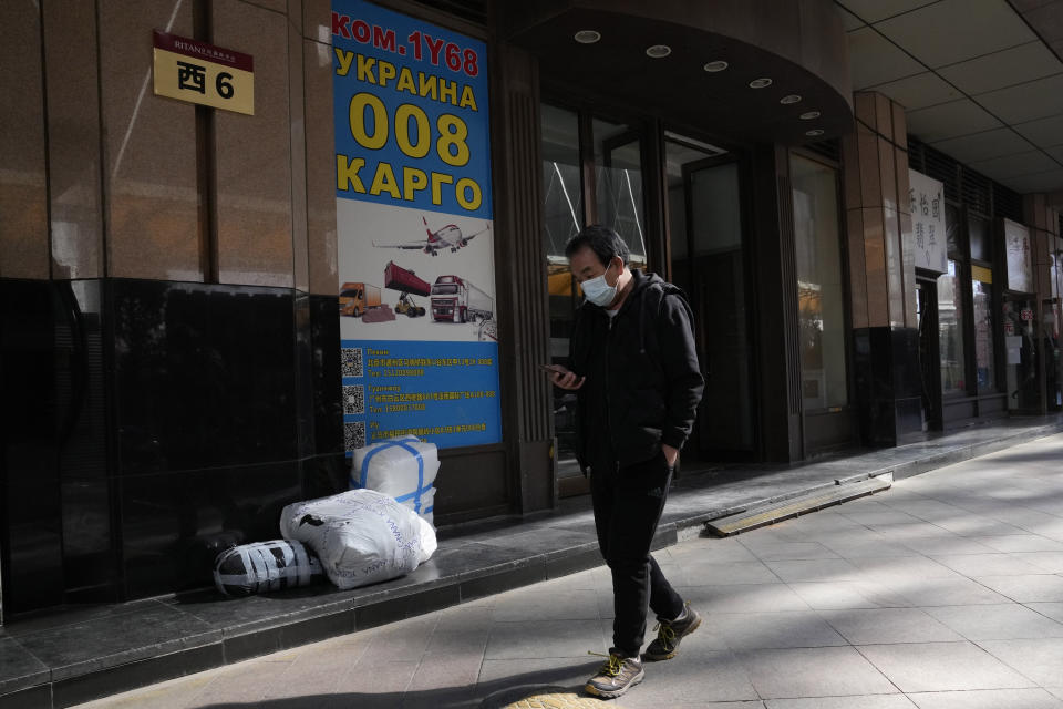 A man wearing a mask walks past a trading center also known as Russia Market for its Russian traders on Saturday, Feb. 26, 2022, in Beijing. China is the only friend that might help Russia blunt the impact of economic sanctions over its invasion of Ukraine, but President Xi Jinping's government is giving no sign it might be willing to risk its own access to U.S. and European markets by doing too much. (AP Photo/Ng Han Guan)