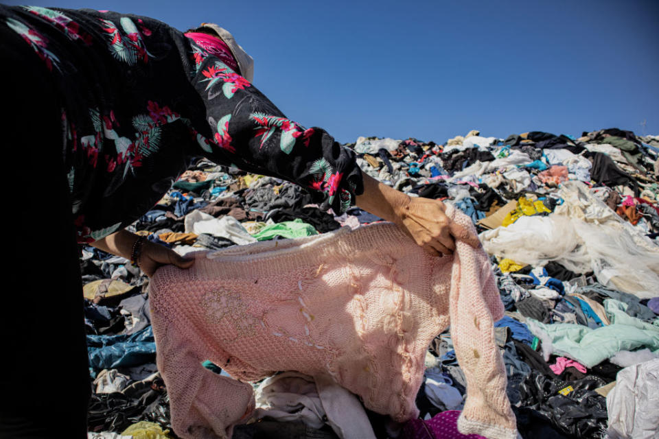 A woman searches for an item of clothing among a mountain of used clothes at a garbage dump in Chile on Nov. 25, 2021.<span class="copyright">Antonio Cossio/dpa Picture Alliance—Getty Images</span>