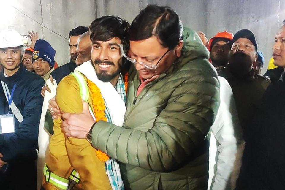 Chief minister of Uttarakhand Pushkar Singh Dhami (R) embracing a contruction worker following his rescue (Department of Information and Pu)