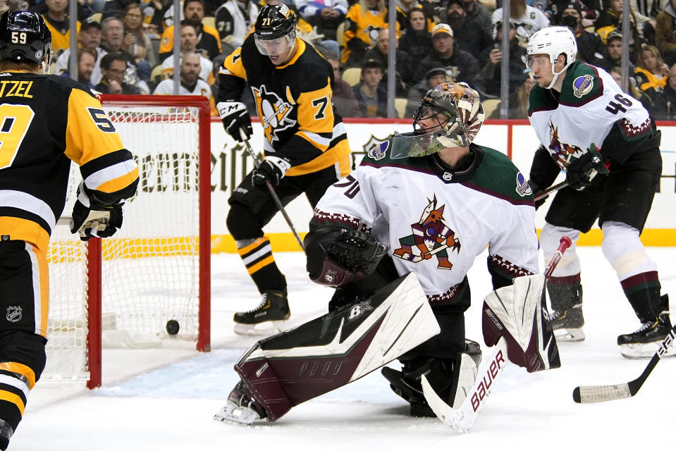 Arizona Coyotes goaltender Karel Vejmelka (70) looks over his shoulder to find a shot by Pittsburgh Penguins' Kris Letang in the net for a goal during the second period of an NHL hockey game in Pittsburgh, Tuesday, Jan. 25, 2022. (AP Photo/Gene J. Puskar)