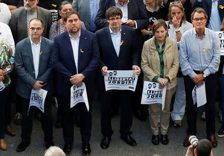 Catalan President Carles Puigdemont (C) and other Catalan regional government members attend a demonstration organised by Catalan pro-independence movements ANC (Catalan National Assembly) and Omnium Cutural, following the imprisonment of their two leaders Jordi Sanchez and Jordi Cuixart, in Barcelona, Spain, October 21, 2017. REUTERS/Gonzalo Fuentes