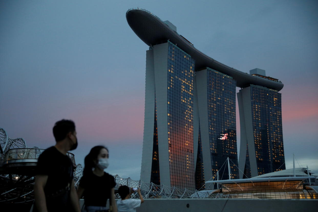 People wearing face masks pass the Marina Bay Sands hotel during the coronavirus disease (COVID-19) outbreak, in Singapore October 28, 2021. REUTERS/Edgar Su