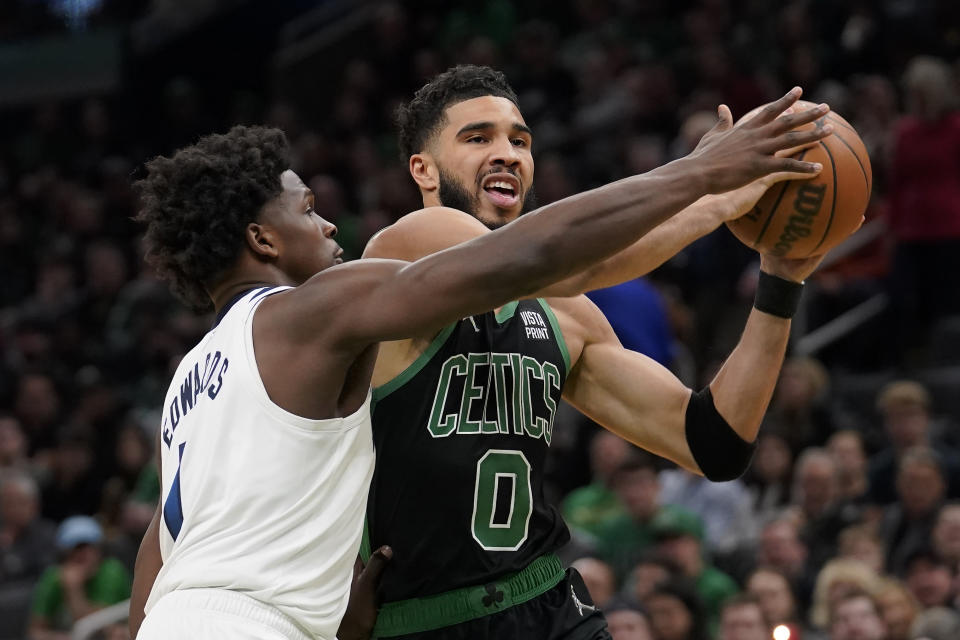 Boston Celtics forward Jayson Tatum (0) drives toward the basket past Minnesota Timberwolves forward Anthony Edwards (1) in the first half of an NBA basketball game, Sunday, March 27, 2022, in Boston. (AP Photo/Steven Senne)