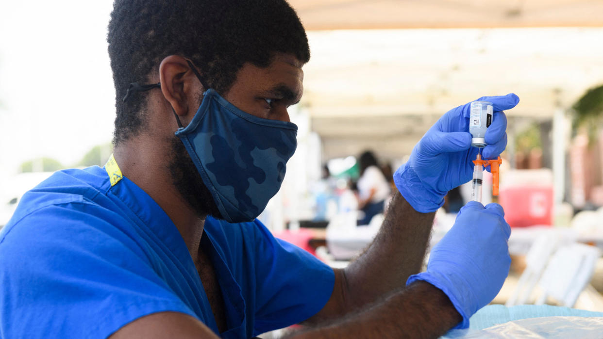 A health care worker prepares a dose of the Moderna Covid-19 vaccine during a Kedren Health mobile vaccine clinic at the Watts Juneteenth Street Fair on June 19, 2021 in the Watts neighborhood of Los Angeles, California. (Patrick T. Fallon/AFP via Getty Images)