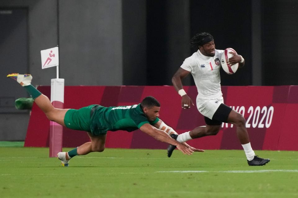 Carlin Isles of the United States evades a tackle by Ireland's Jordan Conroy in their men's rugby sevens match.