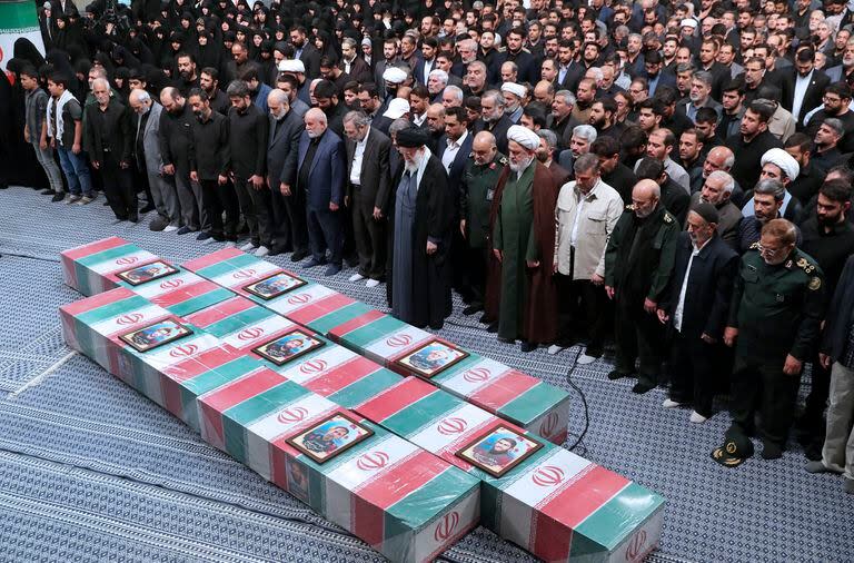 En esta imagen, distribuida por la web oficial de la oficina del líder supremo de Irán, el ayatolá Ali Jamenei (centro, con turbante negro), encabeza una oración junto a los ataúdes, envueltos en banderas nacionales, de los miembros de la Guardia Revolucionaria que murieron en un ataque aéreo en Siria, ampliamente atribuido a Israel, en Teherán, Irán, el 4 de abril de 2024. (Oficina del líder supremo de Irán vía AP)