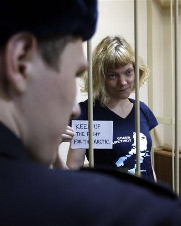 Greenpeace activist Sini Saarela of Finland, one of 30 people arrested over a Greenpeace protest at the Prirazlomnaya oil rig, stands inside a defendants' cage as she attends a court session in St. Petersburg, November 19, 2013. REUTERS/Alexander Demianchuk