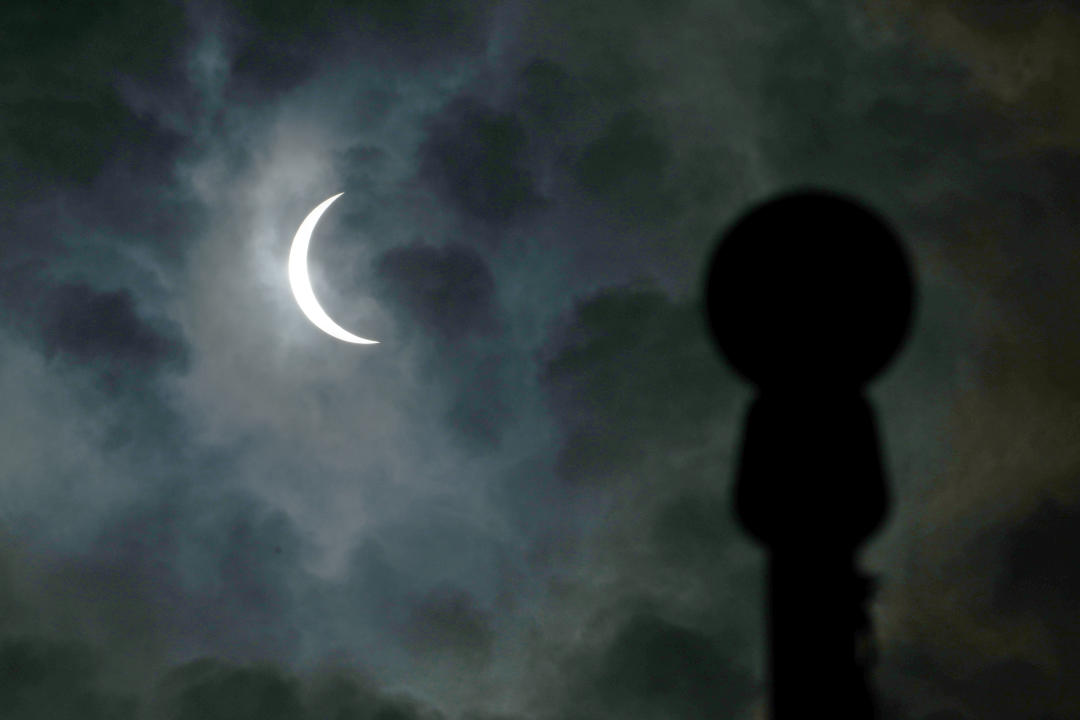 The moon partially covers the sun during a total solar eclipse.