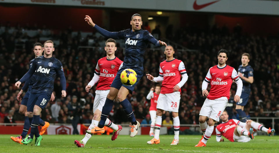 Manchester United's Chris Smalling, centre, watches as the ball goes past and he misses an chance on goal during their English Premier League soccer match between Arsenal and Manchester United at the Emirates stadium in London, Wednesday, Feb. 12, 2014. (AP Photo/Alastair Grant)