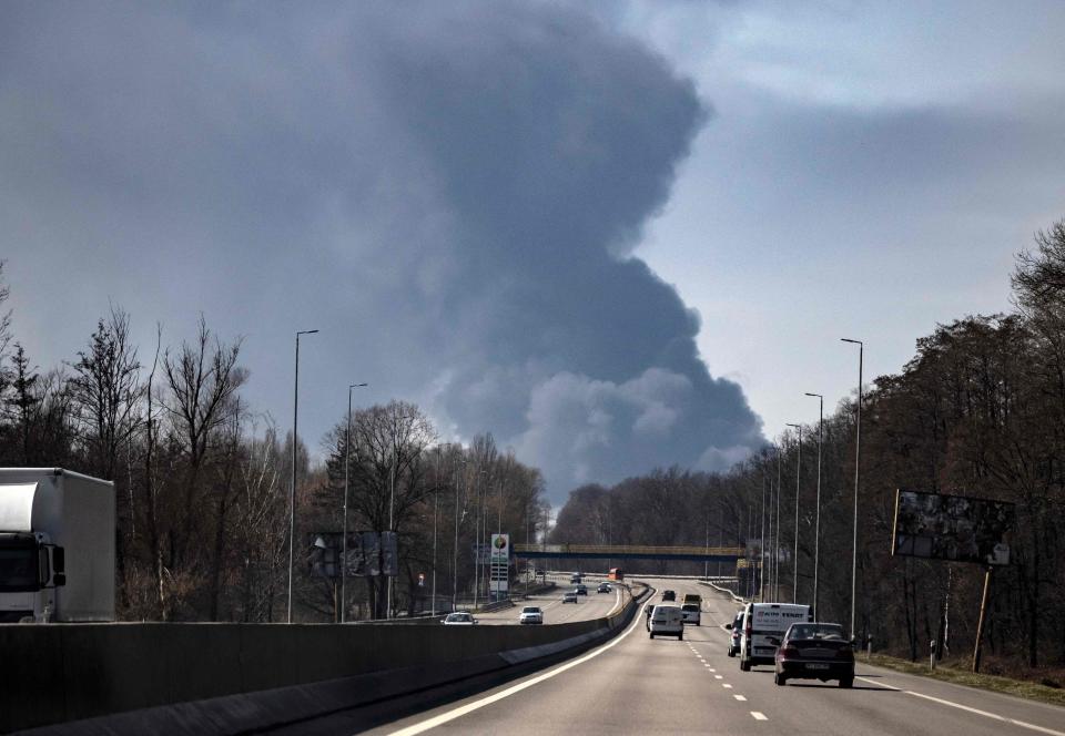 Motorists drive near Kalynivka while smoke rises in the background after the attack on Friday (AFP/Getty)