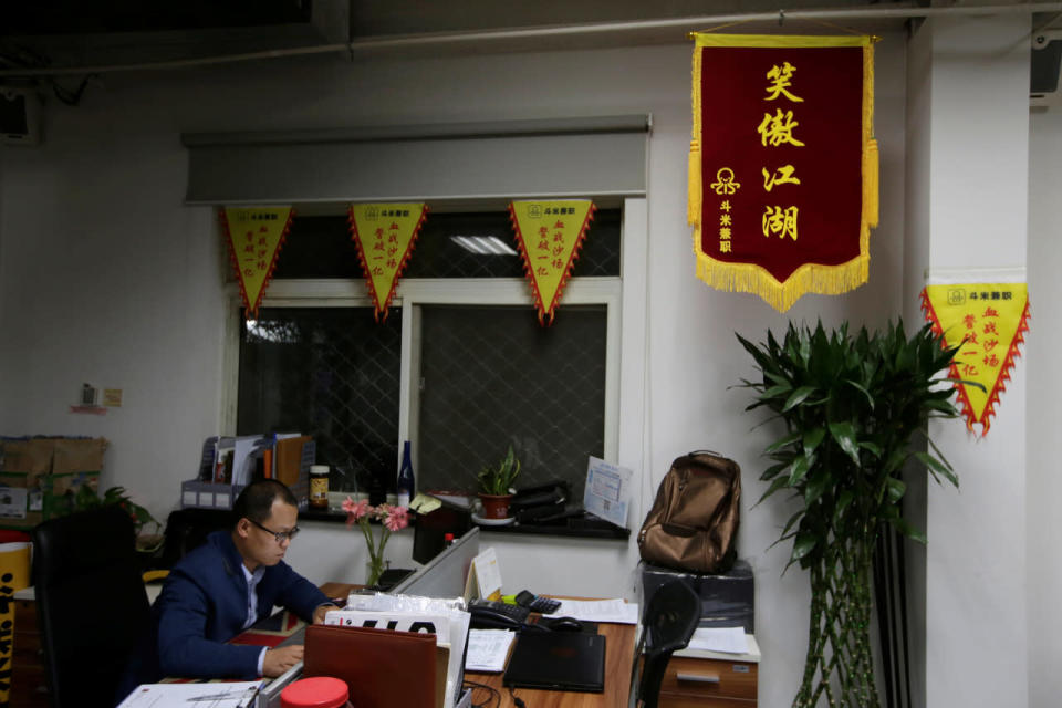 Liu Zhanyu, a client manager at DouMiYouPin, works around midnight in Beijing on April 20, 2016. (Jason Lee/Reuters)