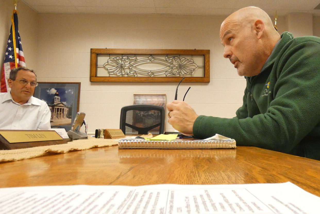 Brad DeCamp, executive director of the Crawford-Marion Board of Alcohol, Drug Addiction and Mental Health Services, right, speaks to Crawford County commissioners during a meeting Thursday. Commissioner Doug Weisenauer is at left.