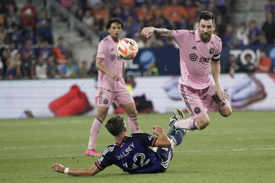 Inter Miami forward Lionel Messi, right, tries to avoid a tackle from FC Cincinnati defender Bret Halsey during the second half of a U.S. Open Cup soccer semifinal Wednesday, Aug. 23, 2023, in Cincinnati. (AP Photo/Joshua A. Bickel)