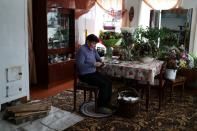 Valentina Fyodorova, 80, the captain of a senior women's hockey team, knits at home in Bereznik