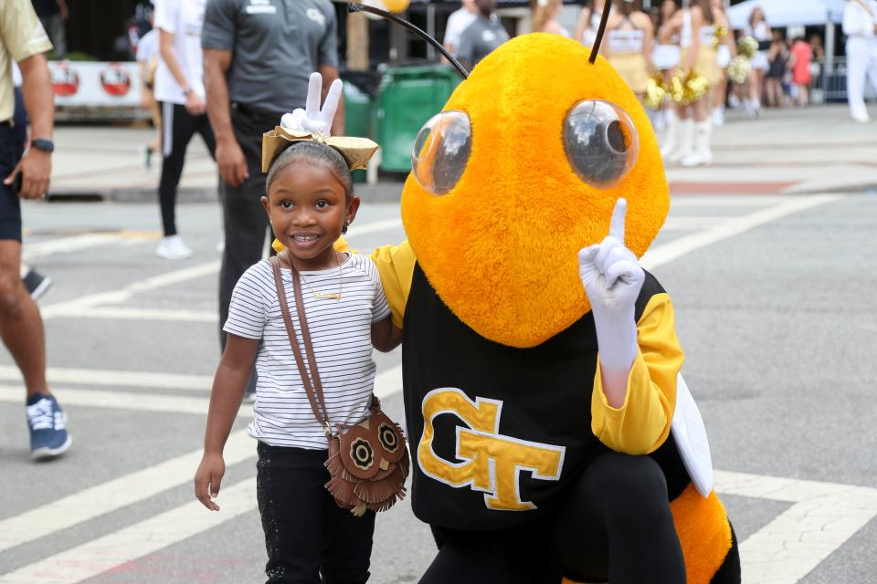 Georgia Tech Yellow Jackets fan Kassidy Watkins has her picture taken with mascot Buzz