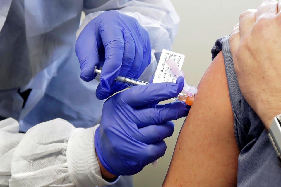 A subject receives a shot in the first-stage safety study clinical trial of a potential vaccine by Moderna for COVID-19.