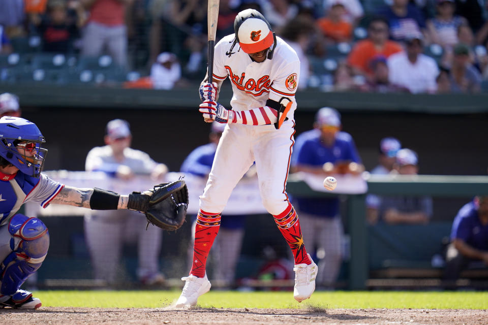 Baltimore Orioles' Jorge Mateo is hit by a pitch from Texas Rangers relief pitcher Matt Moore with the bases loaded to give the Orioles the walkoff win during the 10th inning of a baseball game, Monday, July 4, 2022, in Baltimore. The Orioles won 7-6 in ten innings. (AP Photo/Julio Cortez)