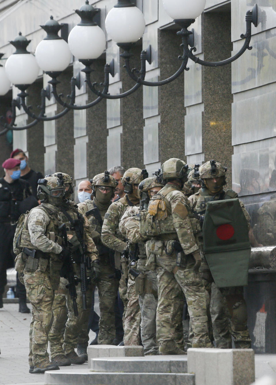 Ukraine's special police prepare to storm a city bank in Kyiv, Ukraine, Monday, Aug. 3, 2020, after a man has threatened to blow up an explosive device inside the bank. The man, identified as Sukhrob Karimov, a 32-year-old citizen of the Central Asian nation of Uzbekistan, entered a bank office in Kyiv and said he had explosives in his backpack. He let bank clerks go and demanded that the authorities invite journalists so that he could make a statement. (AP Photo/Efrem Lukatsky)