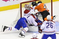 Philadelphia Flyers' Derek Grant (38) and Montreal Canadiens' Xavier Ouellet (61) crash into Canadiens goaltender Carey Price (31) during the first period of an NHL Eastern Conference Stanley Cup hockey playoff game in Toronto, Wednesday, Aug. 12, 2020. (Frank Gunn/The Canadian Press via AP)