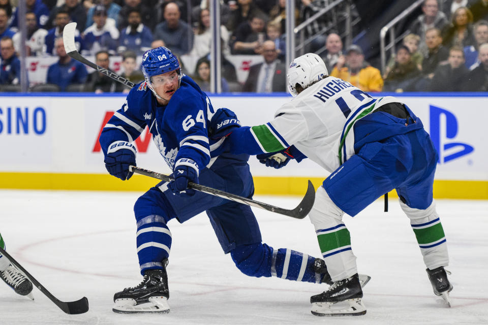 Toronto Maple Leafs centre David Kampf (64) shoots as Vancouver Canucks defenseman Quinn Hughes (43) during the second period of an NHL hockey match in Toronto on Saturday, Nov. 11, 2023. (Christopher Katsarov/The Canadian Press via AP)