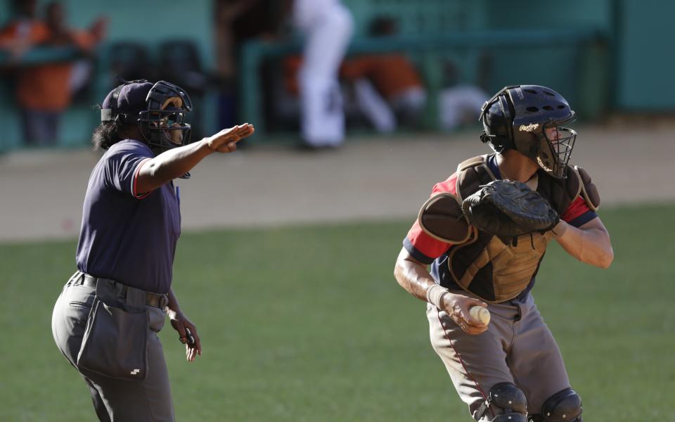 Cuban umpire Yanet Moreno (L) calls a Camaguey player out on strikes as Villa Clara&#39;s catcher holds a ball during a baseball game in Villa Clara October 18, 2014. At 39, she is the only woman in the world umpiring top-flight professional baseball. She is in her 11th season in the National Series, Cuba&#39;s premier baseball league, and says she is ready for the international stage. Cuba has yet to offer Moreno one of its umpiring spots in a top international event for men. Picture taken October 18, 2014. REUTERS/Enrique De La Osa (CUBA - Tags: SPORT BASEBALL)