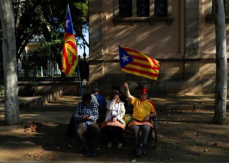 People with Catalan separatist flags sit on a bench outside the Catalan regional parliament in Barcelona, Spain, October 27, 2017. REUTERS/Juan Medina