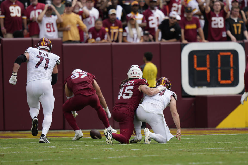 Arizona Cardinals linebacker Cameron Thomas (97) recovers a fumble by Washington Commanders quarterback Sam Howell (14) and scores a touchdown during the first half of an NFL preseason football game, Sunday, Sept. 10, 2023, in Landover, Md. Also seen are Washington Commanders guard Andrew Wylie (71) and Arizona Cardinals linebacker Dennis Gardeck (45). (AP Photo/Alex Brandon)