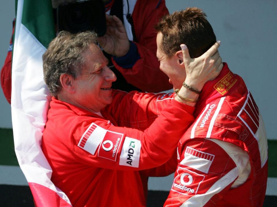 Ferrari Formula One driver Michael Schumacher of Germany, right, holding the Italian flag is congratulated by Ferrari team manager Jean Todt after winning the French Formula One Grand Prix.