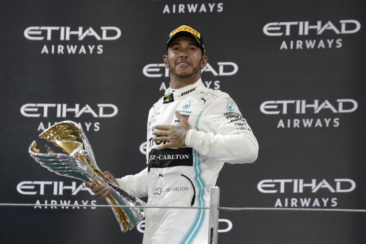 Mercedes driver Lewis Hamilton of Britain celebrates on the podium after winning the Emirates Formula One Grand Prix at the Yas Marina racetrack in Abu Dhabi, United Arab Emirates, Sunday, Dec.1, 2019. (AP Photo/Hassan Ammar)