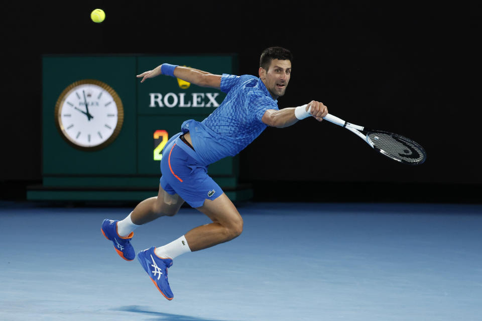 Novak Djokovic of Serbia plays a backhand to Stefanos Tsitsipas of Greece during the men's singles final at the Australian Open tennis championships in Melbourne, Australia, Sunday, Jan. 29, 2023. (AP Photo/Asanka Brendon Ratnayake)