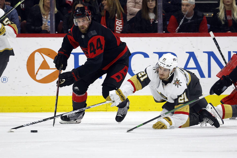 Carolina Hurricanes' Calvin de Haan (44) and Vegas Golden Knights' Brett Howden (21) battle for the puck during the second period of an NHL hockey game in Raleigh, N.C., Saturday, March 11, 2023. (AP Photo/Karl B DeBlaker)