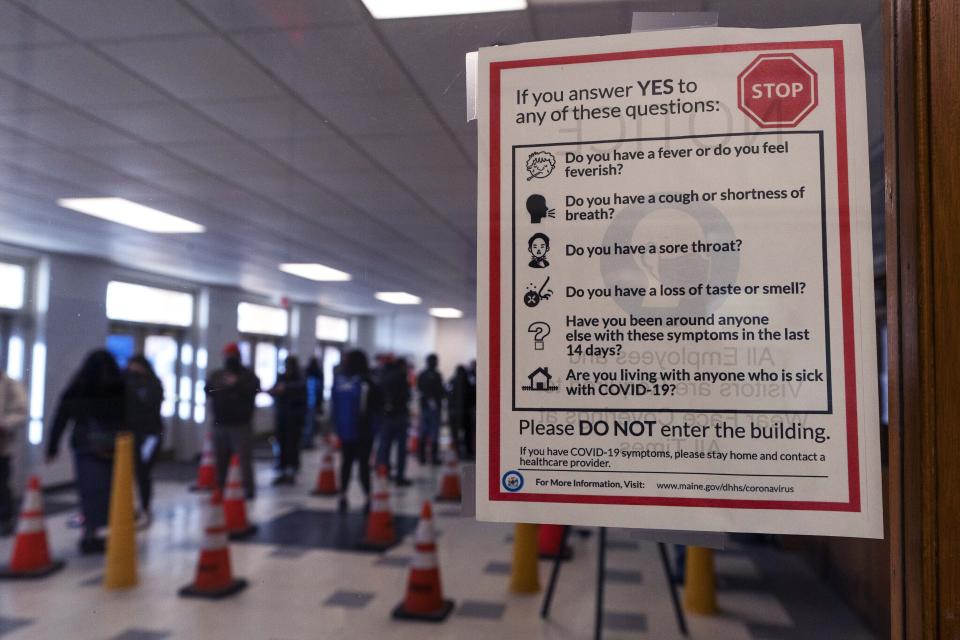 A sign warns people with COVID-19 symptoms to not enter a vaccination clinic at the Augusta Armory, Tuesday, Dec. 21, 2021, in Augusta, Maine. U.S. health officials are calling on Americans to get tested for COVID-19 before they travel and gather for the holidays. But what should you do if you test positive? (AP Photo/Robert F. Bukaty)