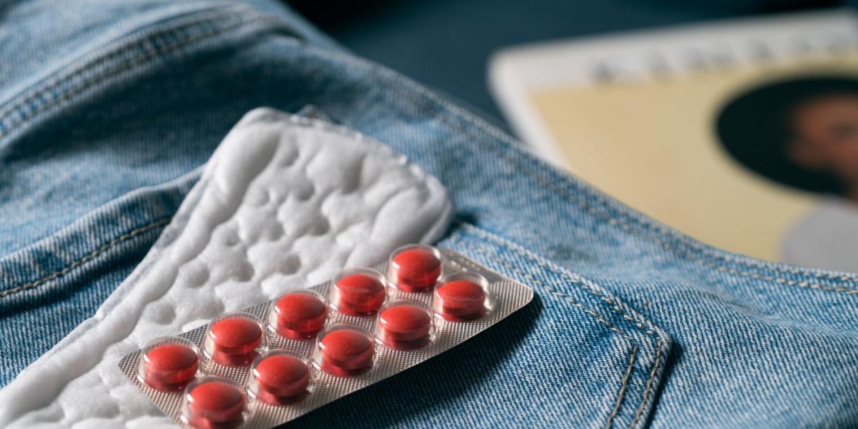 sanitary towel and pill packet on some jeans