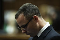 Oscar Pistorius stands in the dock in court in Pretoria, South Africa, Wednesday, May 14, 2014, as the judge overseeing his murder trial ordered him to undergo psychiatric tests. The court adjourned until May 21, 2014. (AP Photo/Gianluigi Guercia - Pool)