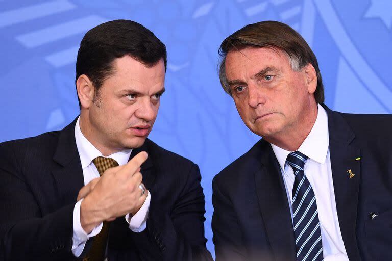 Presidente de Brasil Jair Bolsonaro y su ministro de Justicia Anderson Torres hablan durante un evento para presentar la nueva identificación nacional y pasaporte en el Palacio de Planalto en Brasilia el 27 de junio de 2022
(EVARISTO SA / AFP)