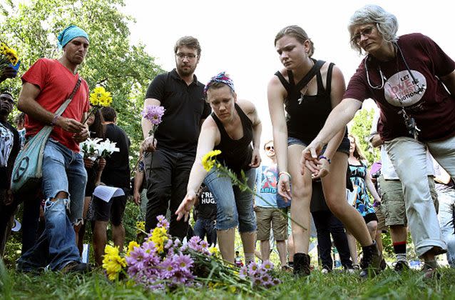 People place flowers at a makeshift memorial during a vigil for those who were injured and died. Picture: Getty/Win McNamee