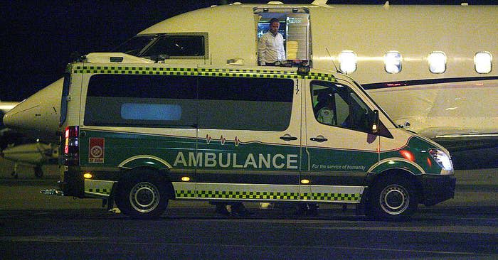 Ambulance vehicle parked, with opened back doors and visible medical equipment inside