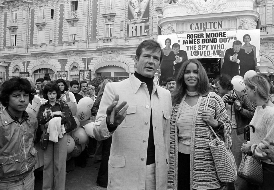 FILE - In this May 20, 1977 file photo, actor Roger Moore, alias British secret agent James Bond, is accompanied by co-star Barbara Bach as they arrive for the screening of their latest 007 feature, "The Spy Who Loved Me," during the Cannes Film Festival at the French Riviera. Moore, played Bond in seven films, more than any other actor. (AP Photo, File)