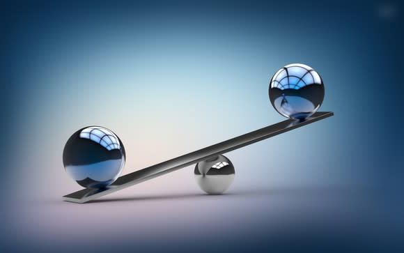 A see-saw with two polished metallic spheres on it, unbalanced.