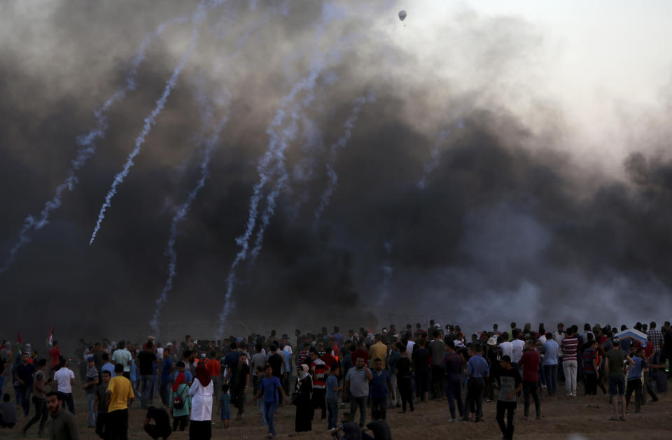 Protesters gather while Israeli troops fired teargas near the fence of Gaza Strip border with Israel during a protest east of Gaza City, Friday, Sept. 14, 2018. Gaza health officials say 3 Palestinians, including 12-year-old boy, were killed by Israeli army fire in protests along Gaza's perimeter fence. (AP Photo/Adel Hana)