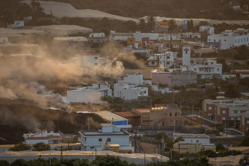 Lava flows from a volcano destroying houses at La Laguna neighbourhood on the Canary island of La Palma, Spain on Thursday Oct. 21, 2021. A second tongue of lava is expected to reach the Atlantic today and release more toxic gases into the atmosphere, an event which will lead to the home confinement of some nearby towns. (AP Photo/Saul Santos)