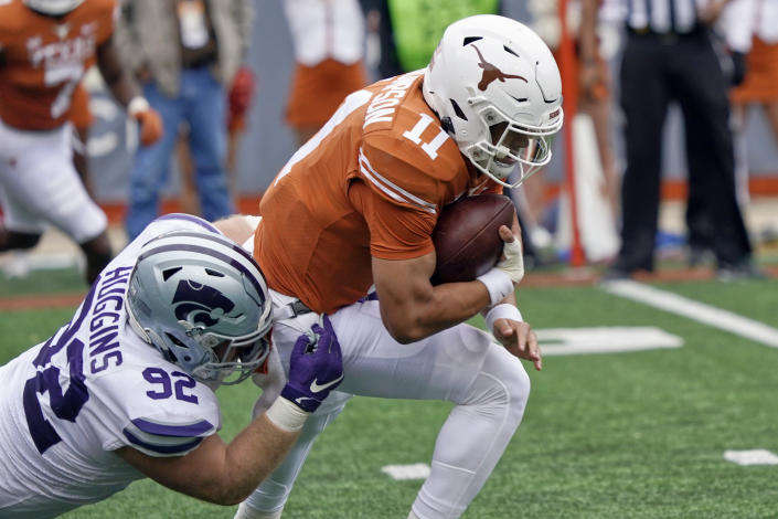 Texas quarterback Casey Thompson (11) is sacked by Kansas State defensive tackle Eli Huggins (92) during the first half of an NCAA college football game in Austin, Texas, Friday, Nov. 26, 2021. (AP Photo/Chuck Burton)