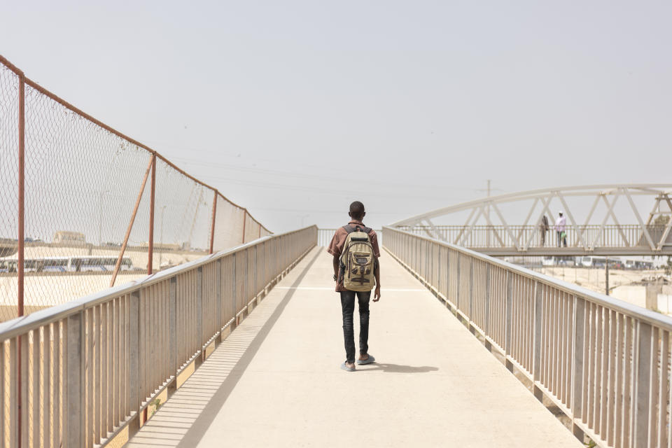 Mouhamed Sall, who is deaf, walks home after school in Pikine, Senegal, Monday, March 18, 2024. Sall and three other students are part of a new approach in a small number of schools in Senegal that seat those who are deaf and hard of hearing with the rest of the class. (AP Photo/Sylvain Cherkaoui)