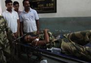 An Indian soldier wounded during a cross-border exchange with his Pakistani counterparts is brought to hospital in Jammu, on October 9, 2014